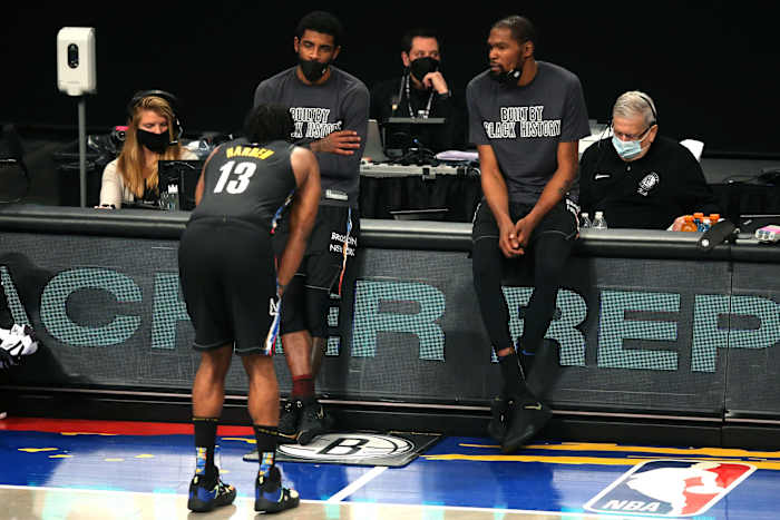 Brooklyn Nets point guard Kyrie Irving (C) and power forward Kevin Durant (R) talk to shooting guard James Harden (13)